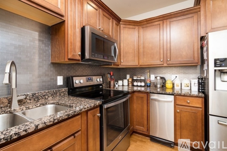 A kitchen with wooden cabinets and a granite countertop.