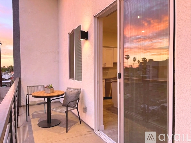 A balcony with a table and chairs is shown.