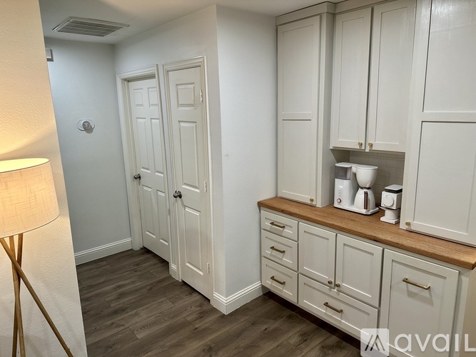 A kitchen with white cabinets and a wooden countertop.