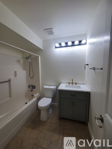 A bathroom with a toilet, sink, and bathtub.