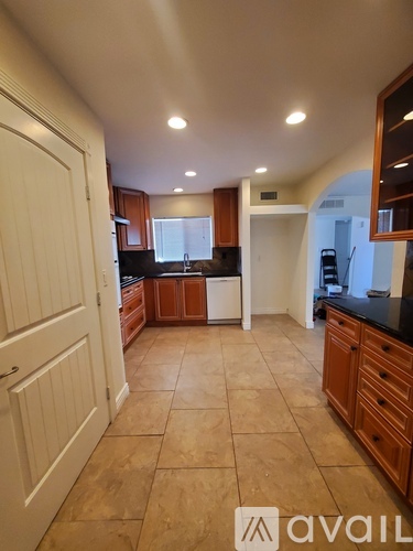A kitchen with wooden cabinets and a white door.