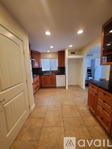 A kitchen with wooden cabinets and a white door.