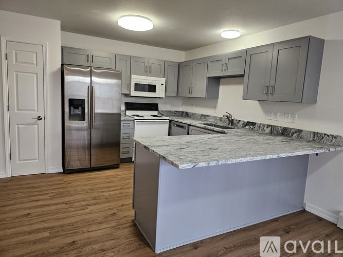A kitchen with a refrigerator, microwave, and oven.