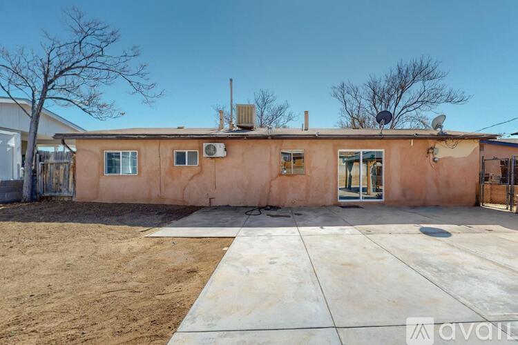A building with a brown wall and a concrete ground in front of it.