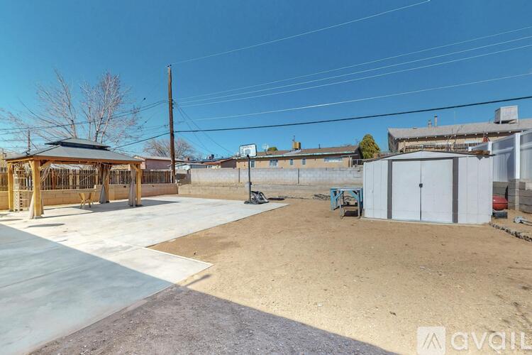 A parking lot with a gazebo and a building in the background.