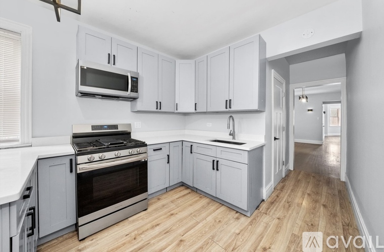 A kitchen with wooden floors and white cabinets.