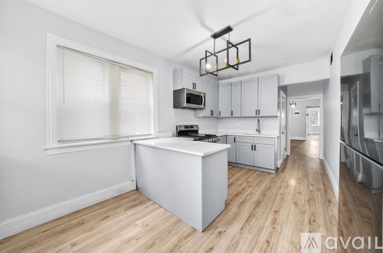 A kitchen with white cabinets and a wooden floor.