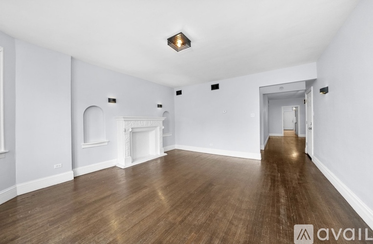 A spacious room with wooden floors and white walls.