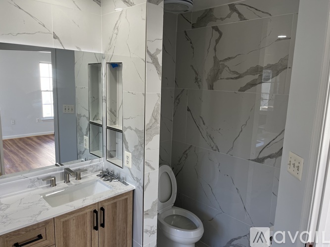 A bathroom with a marble wall and a bathtub.
