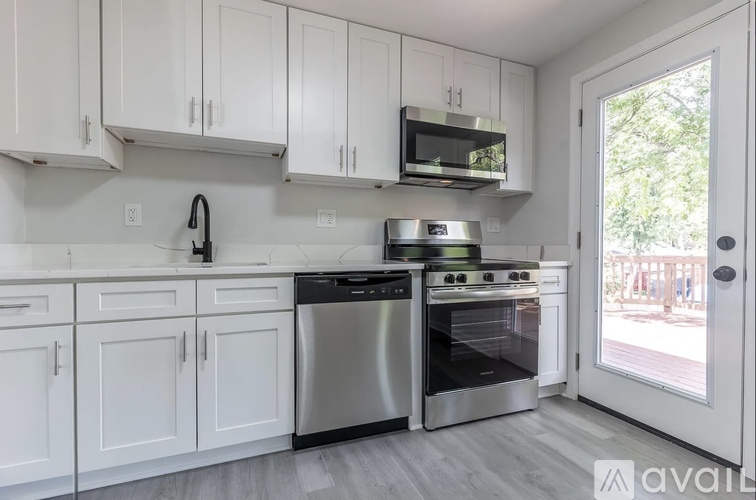 A kitchen with white cabinets and stainless steel appliances.