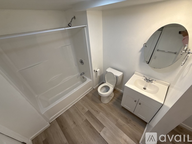 A bathroom with a toilet, sink, and shower.