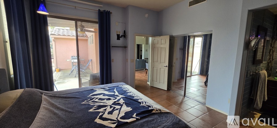 A bedroom with a bed and a blue blanket with white letters on it.