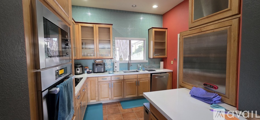 A kitchen with wooden cabinets and a stainless steel refrigerator.