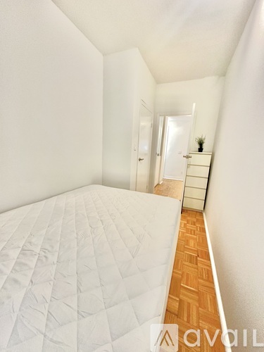 A bedroom with a bed and a window with a view of a brick wall.