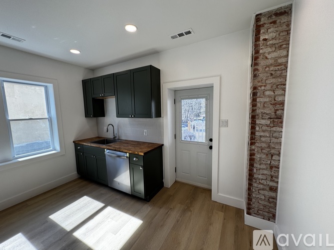 A kitchen with black cabinets and a wooden countertop.