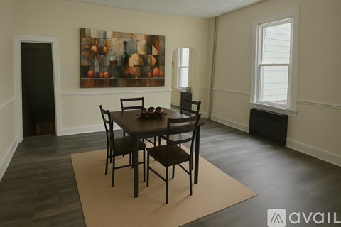 A dining room with a table and chairs.