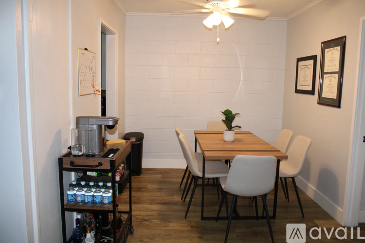 A small dining room with a wooden table and white chairs.