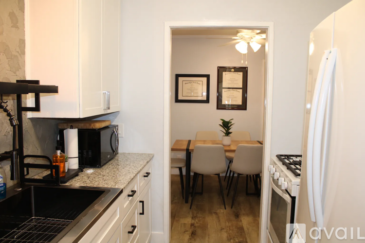A kitchen with a dining table and chairs in the background.