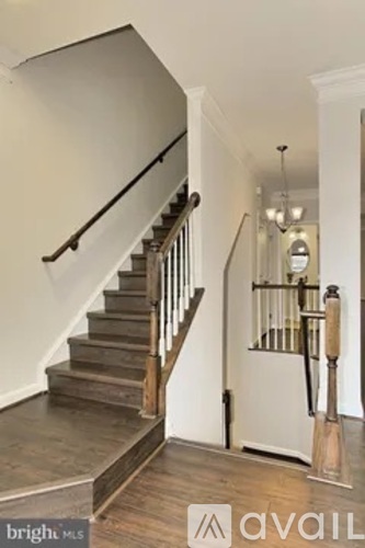 A staircase with a wooden handrail and a metal balustrade.