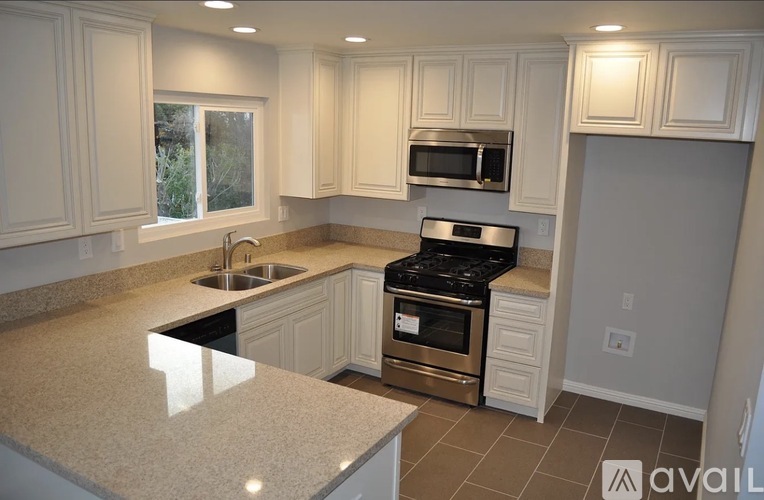 A kitchen with a granite countertop and stainless steel appliances.