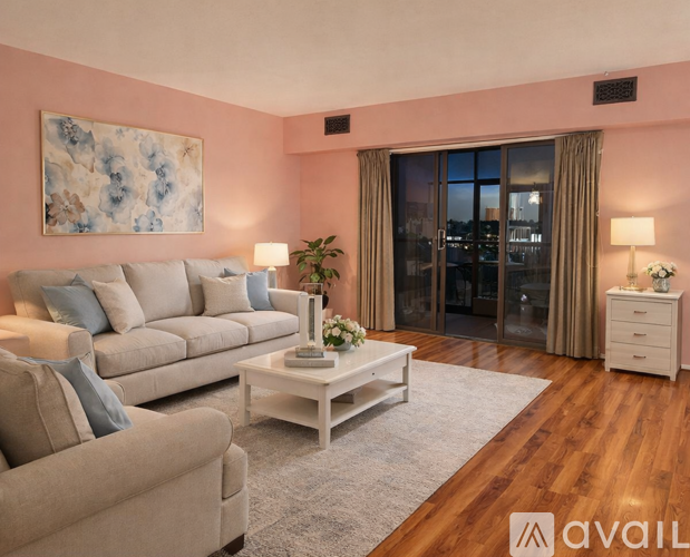 A living room with a beige couch, a white coffee table, and a painting on the wall.
