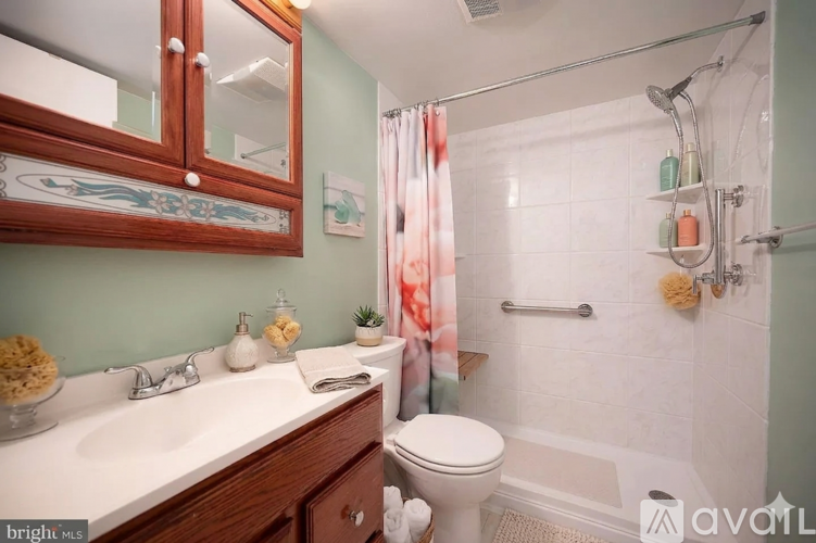 A bathroom with a toilet, sink, and shower.