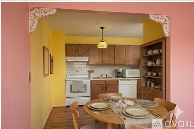 A kitchen with yellow walls and a dining table set for four.