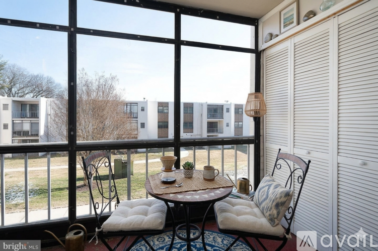A balcony with a table and chairs overlooking apartment buildings.