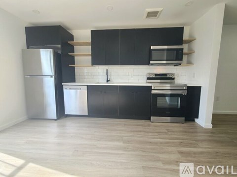 A kitchen with black cabinets and stainless steel appliances.