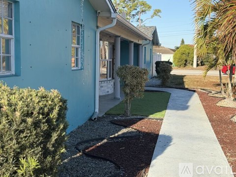 A blue house with a white door and windows.
