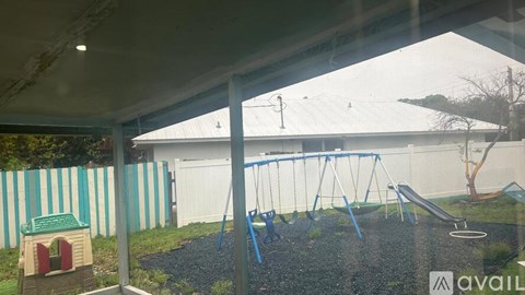 A playground with a swing set and a green slide.