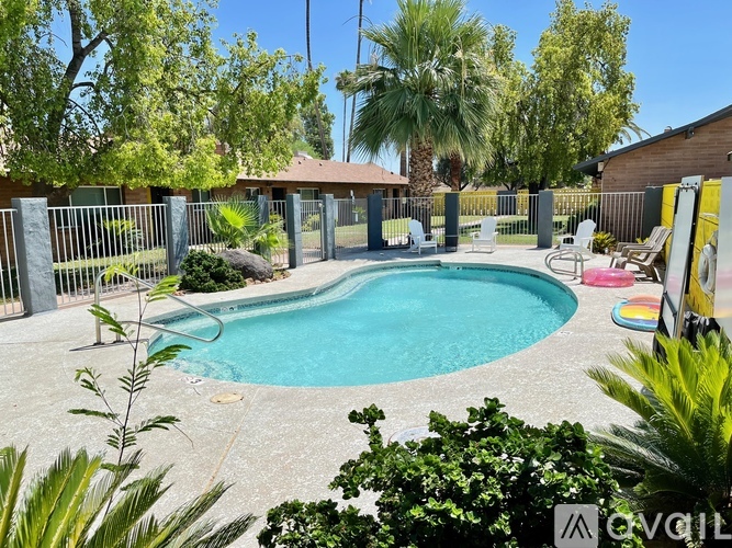 A pool surrounded by a fence and trees.