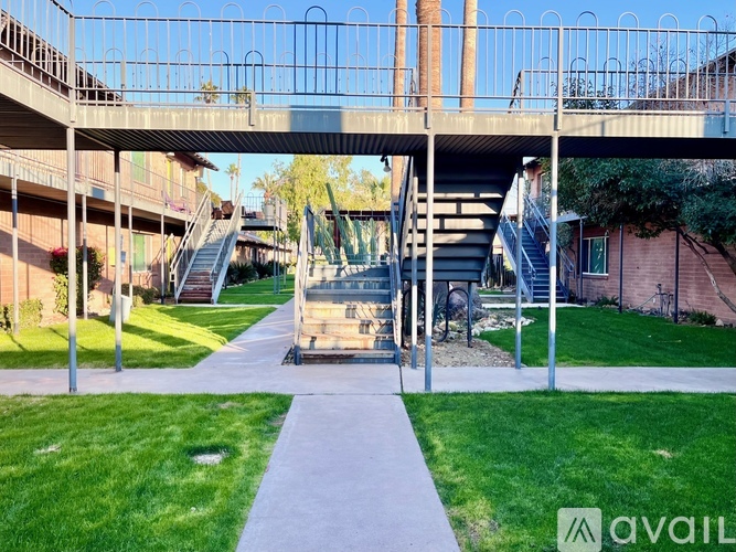 A concrete staircase with metal railings leads up to a building.