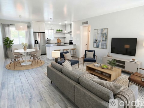 A modern living room with a grey sofa, a round table with four chairs, and a television on the wall.