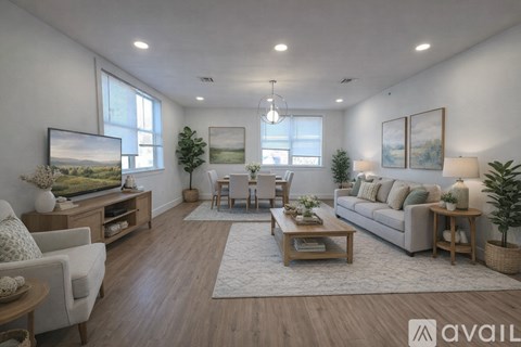 A well-lit living room with a white sofa, wooden coffee table, and a large painting on the wall.