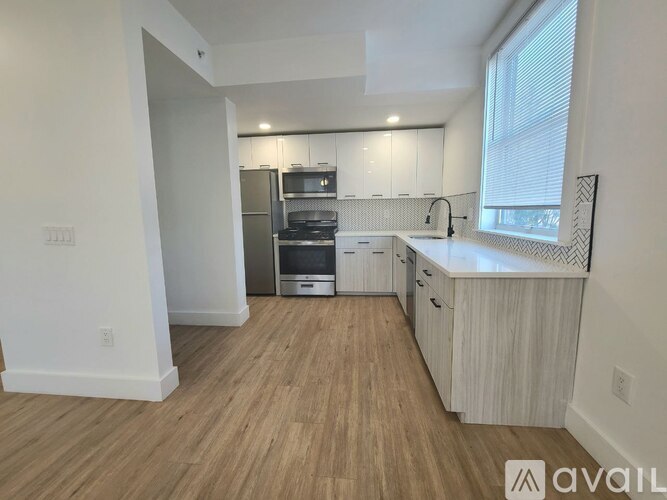 A kitchen with white cabinets and a wooden floor.