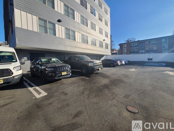 A parking lot with several cars and a building in the background.