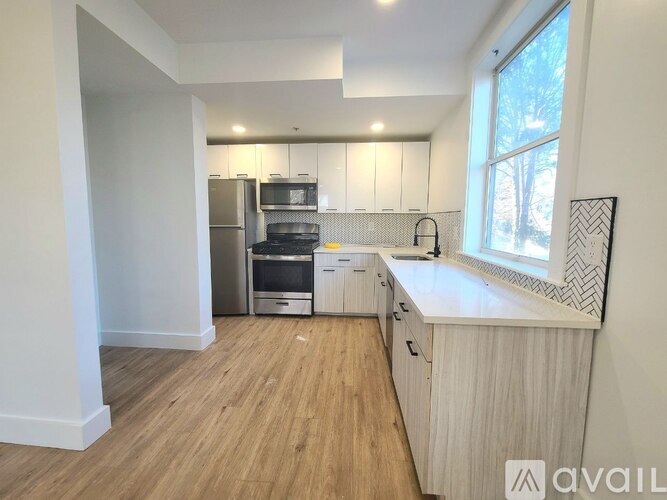 A kitchen with wooden floors and white walls.