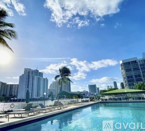 A sunny day at the pool with palm trees and modern buildings in the background.
