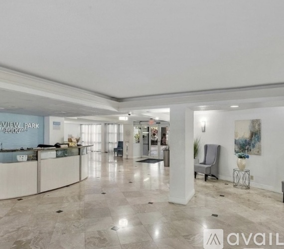 A spacious lobby with a reception desk and a large painting on the wall.