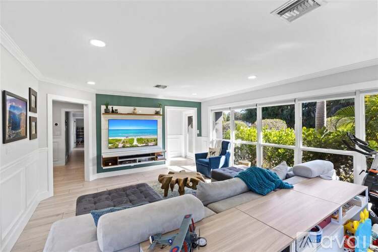 A living room with a large window overlooking a beach.