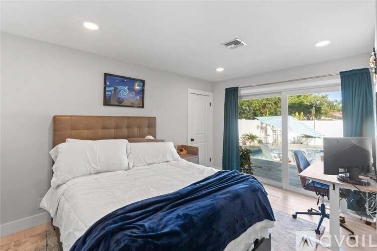 A bedroom with a large bed and a desk with a computer.