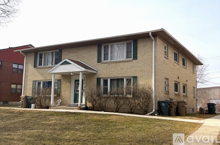 A two-story house with a front porch and a covered entryway.