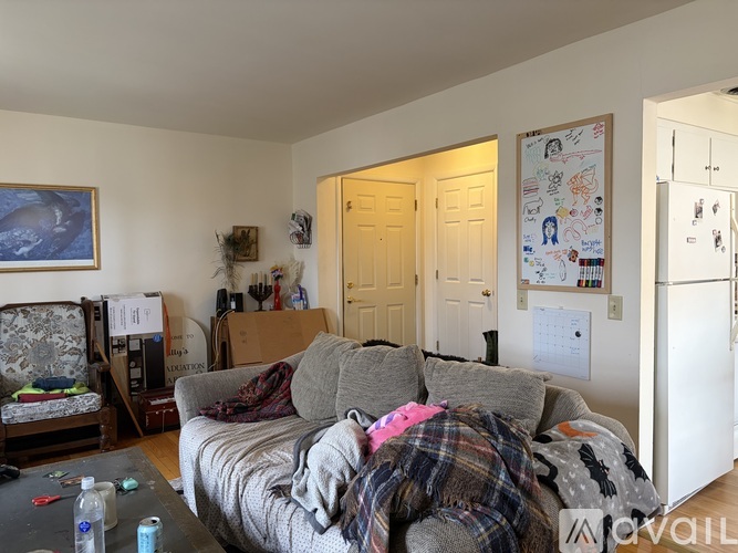 A living room with a grey couch and a painting on the wall.