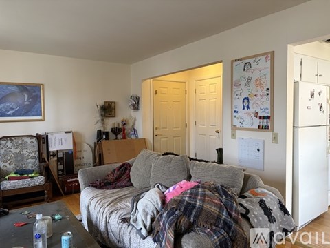 A living room with a grey couch and a painting on the wall.