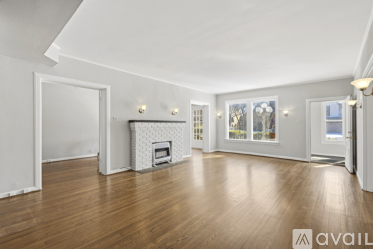 A spacious living room with a fireplace and hardwood floors.