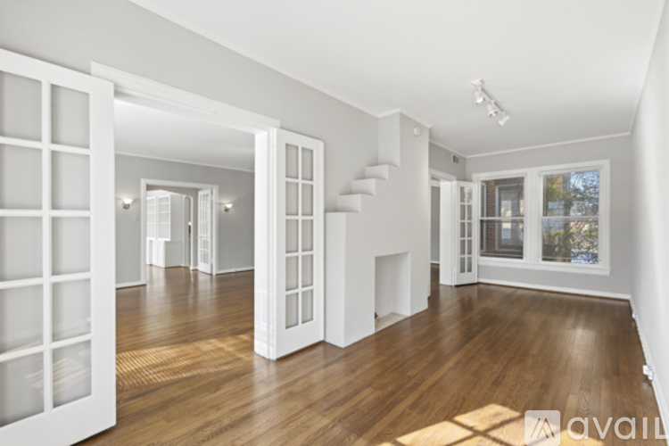 A spacious room with wooden floors and white walls.