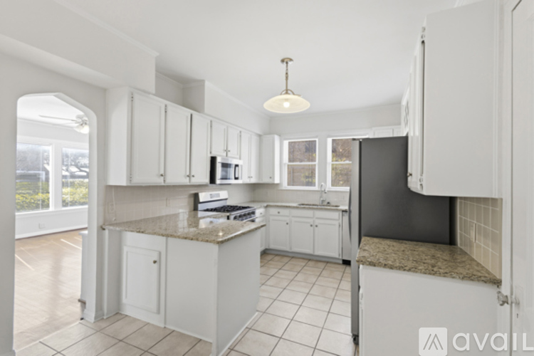 A kitchen with white cabinets and a granite countertop.