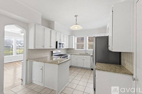 A kitchen with white cabinets and a granite countertop.