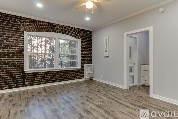 A room with a brick wall and a window.
